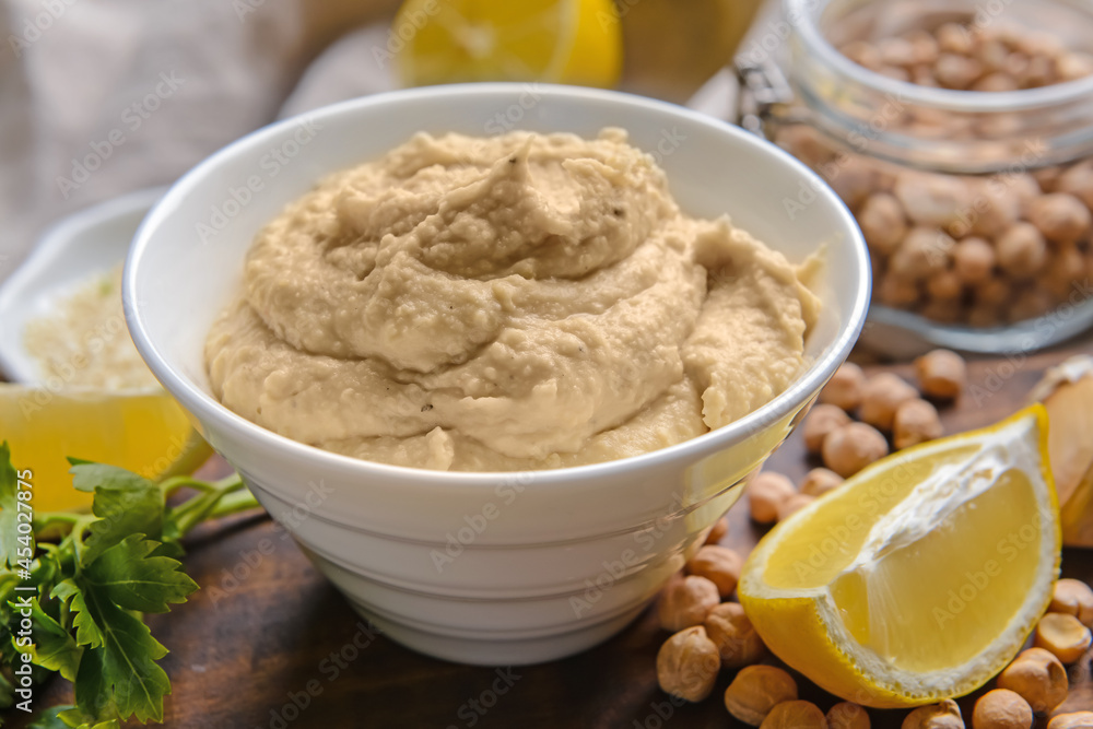 Bowl with tasty hummus and ingredients on table, closeup Bowl with tasty hummus and ingredients on table, closeup
