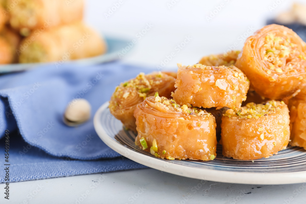 Plate with delicious baklava on light background, closeup Plate with delicious baklava on light background, closeup
