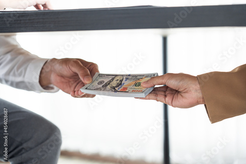 two hands passing bills making agreement to initiate the new business