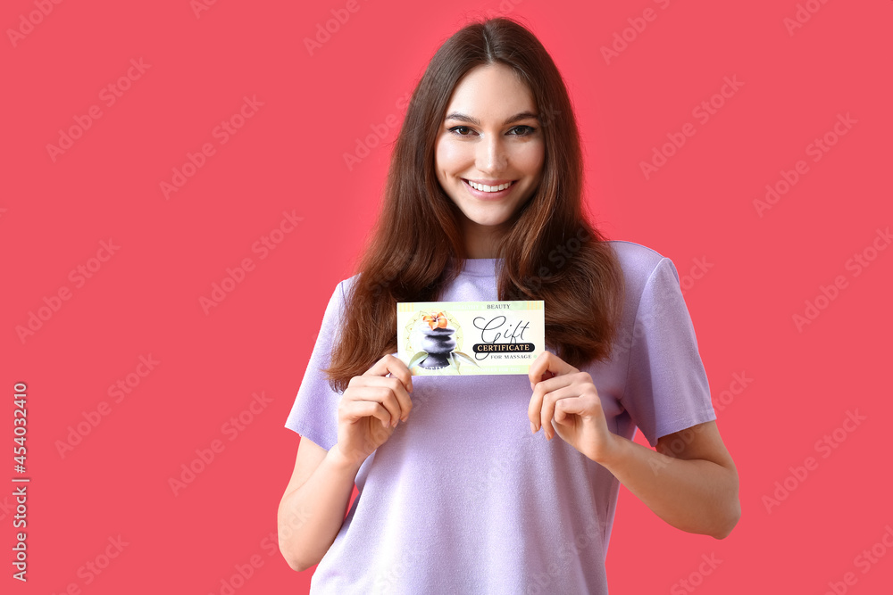 Young woman with gift certificate for massage on color background Young woman with gift certificate for massage on color background