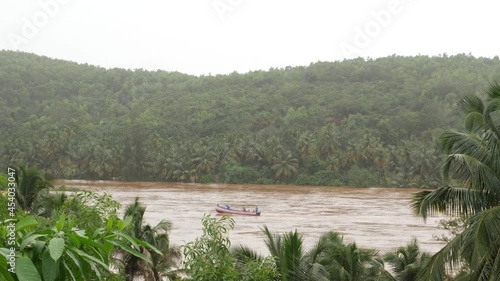 View of moving boat in flood water with trees in background photo