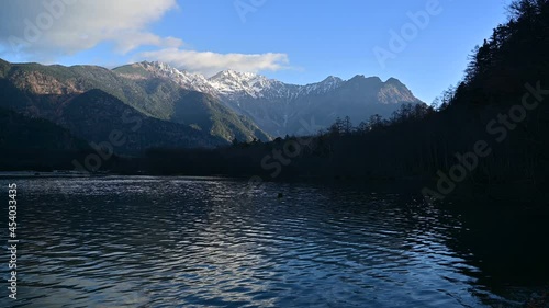 朝日を浴びて輝く穂高連峰と静寂に包まれた早朝の大正池のコラボ情景＠上高地、長野