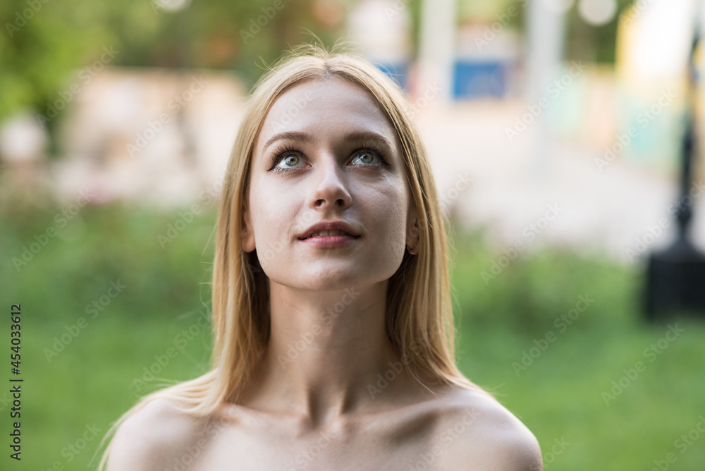Hopeful Caucasian woman standing outside looking at sky in contemplation Hopeful Caucasian woman standing outside looking at sky in contemplation