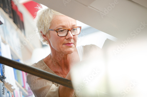 Low angle view of older woman reading book