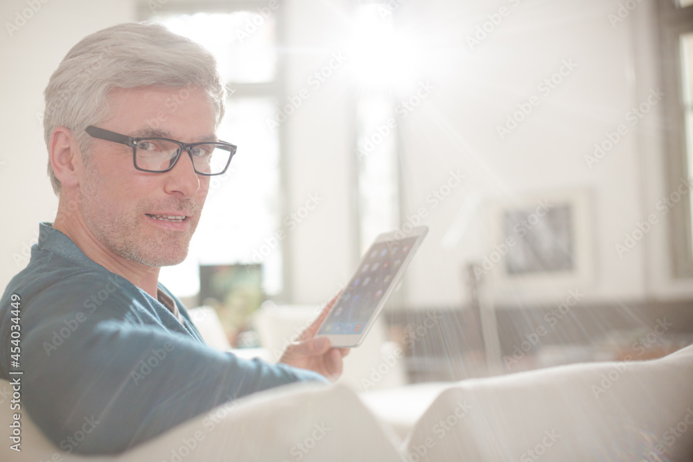 Older man using digital tablet on living room sofa Older man using digital tablet on living room sofa