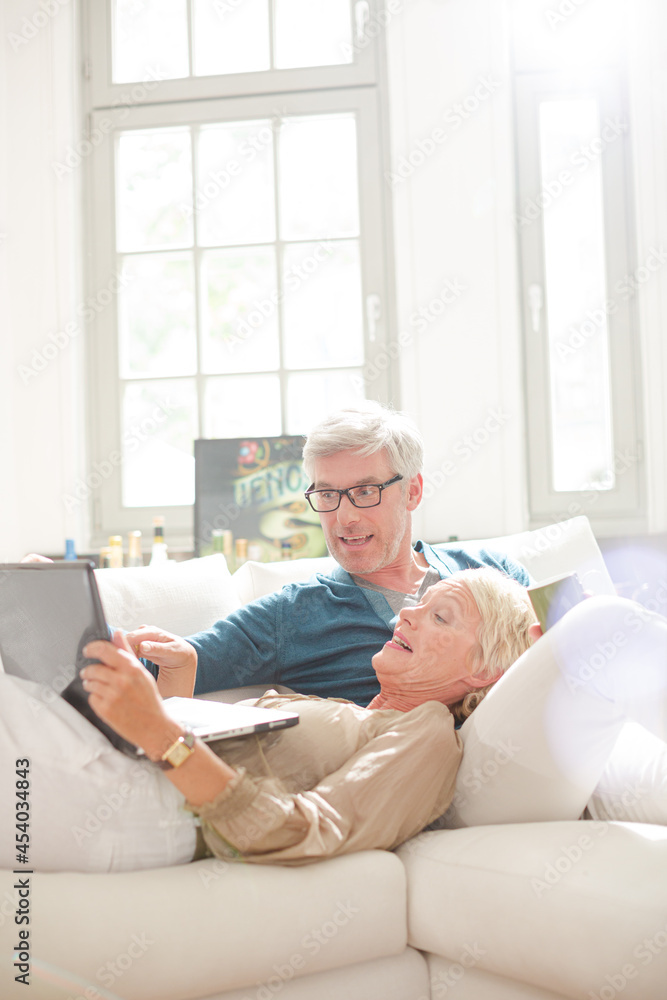 Older couple relaxing together on living room sofa Older couple relaxing together on living room sofa