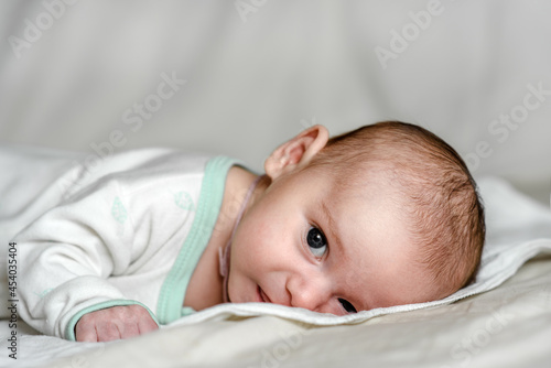A newborn charming baby in white. Close-up portrait.