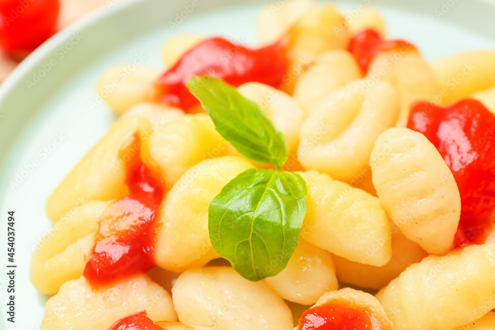 Delicious gnocchi with tomato sauce in plate, closeup