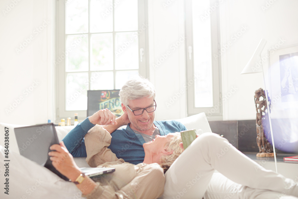Older couple relaxing together on living room sofa Older couple relaxing together on living room sofa