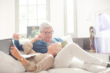 Older couple relaxing together on living room sofa