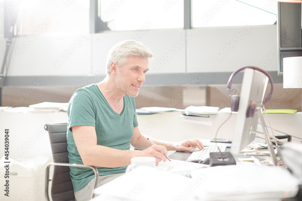 Smiling older man sitting at desk Smiling older man sitting at desk