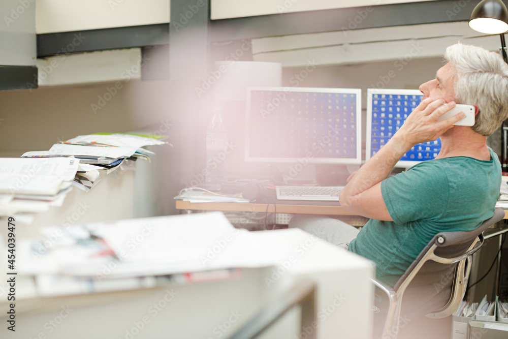 Businessman talking on cell phone at office desk Businessman talking on cell phone at office desk
