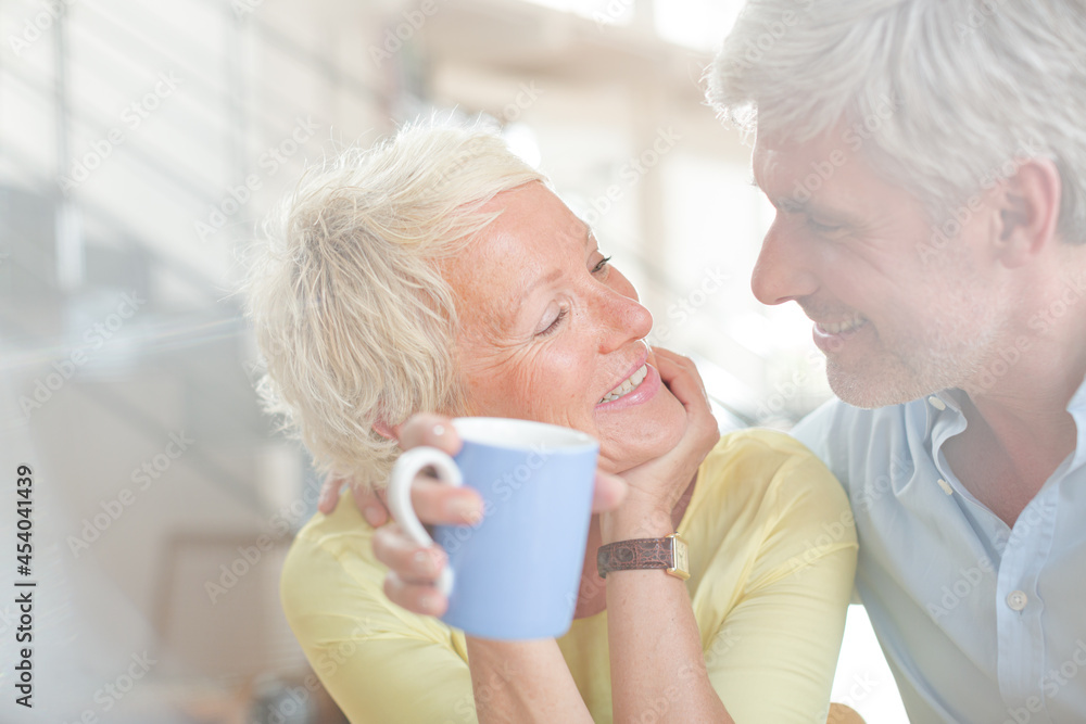 Older couple hugging with coffee cup Older couple hugging with coffee cup