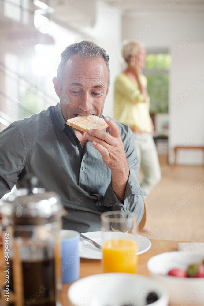 Older man using digital tablet at breakfast table Older man using digital tablet at breakfast table