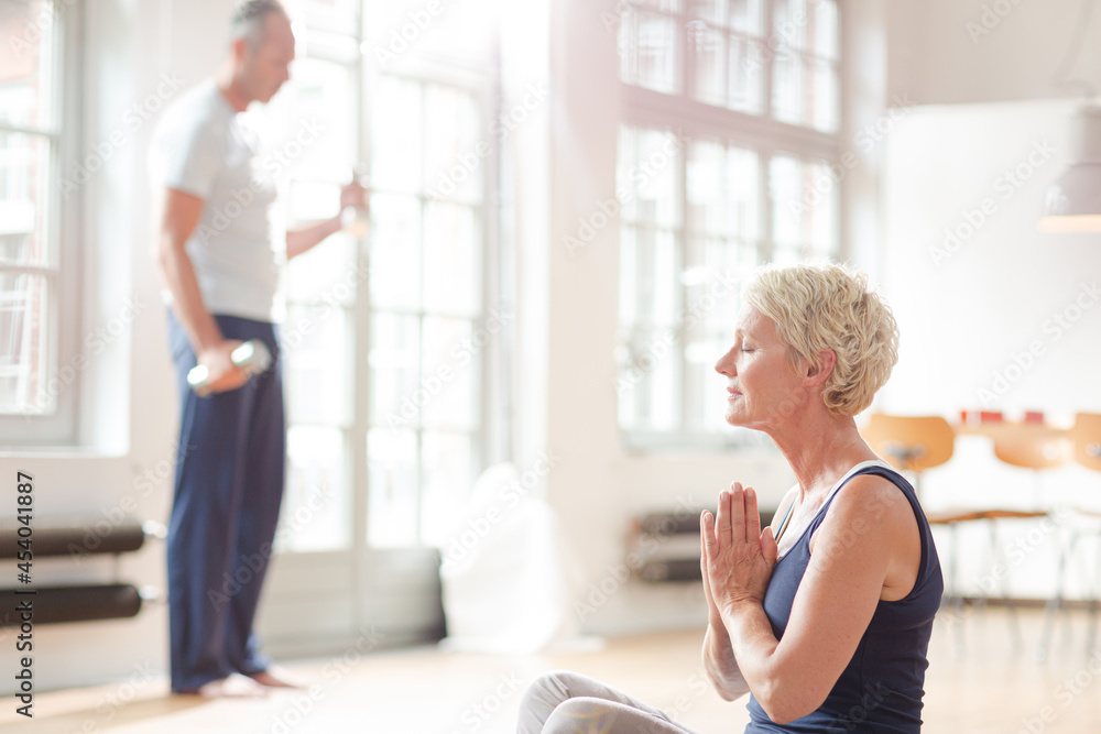 Older woman meditating on floor Older woman meditating on floor