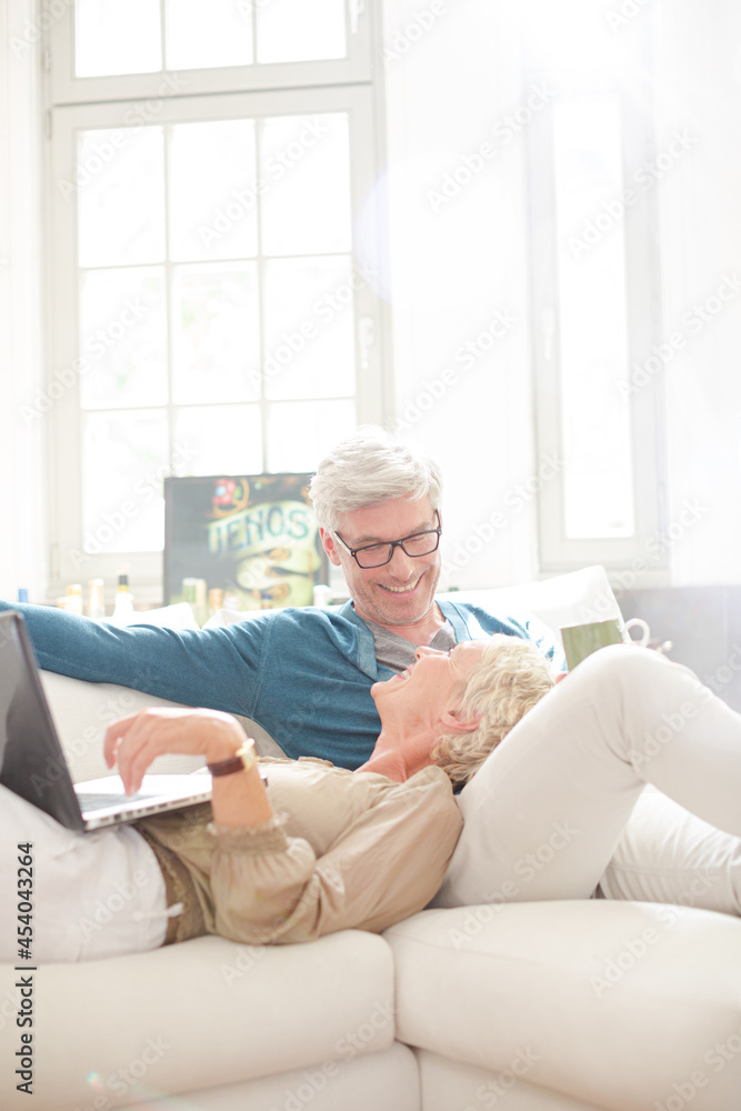 Older couple relaxing together on living room sofa Older couple relaxing together on living room sofa