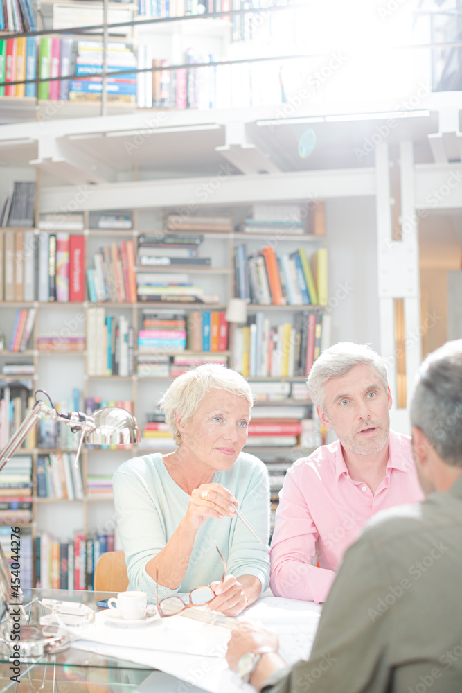 Business people reading paperwork in office meeting