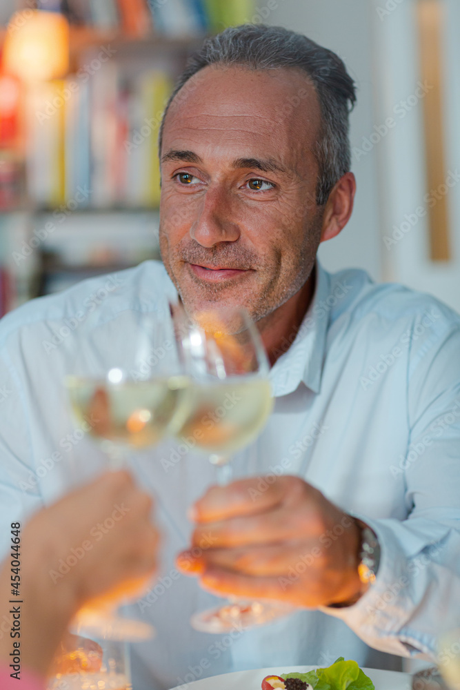 Older man drinking white wine at dinner Older man drinking white wine at dinner
