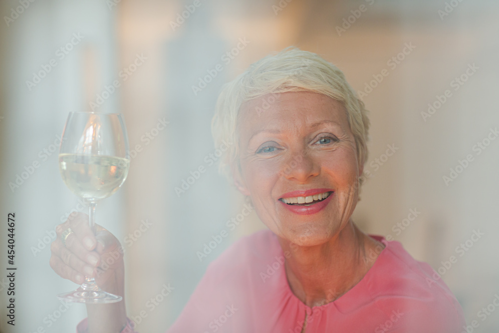 Older woman drinking glass of white wine Older woman drinking glass of white wine