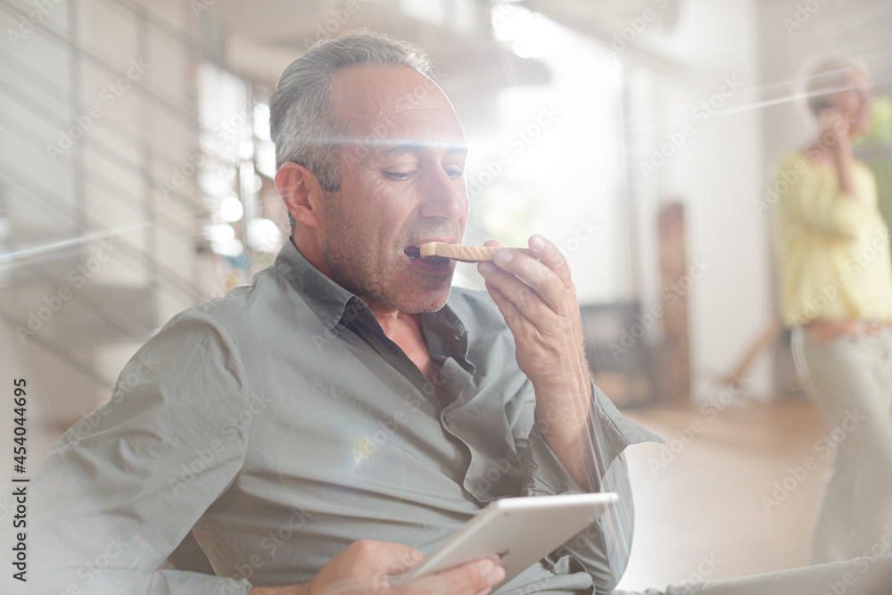 Older man using digital tablet at breakfast table Older man using digital tablet at breakfast table