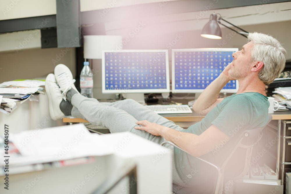 Fototapeta premium Businessman talking on cell phone at office desk