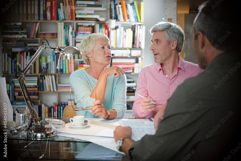 Business people reading paperwork in office meeting Business people reading paperwork in office meeting