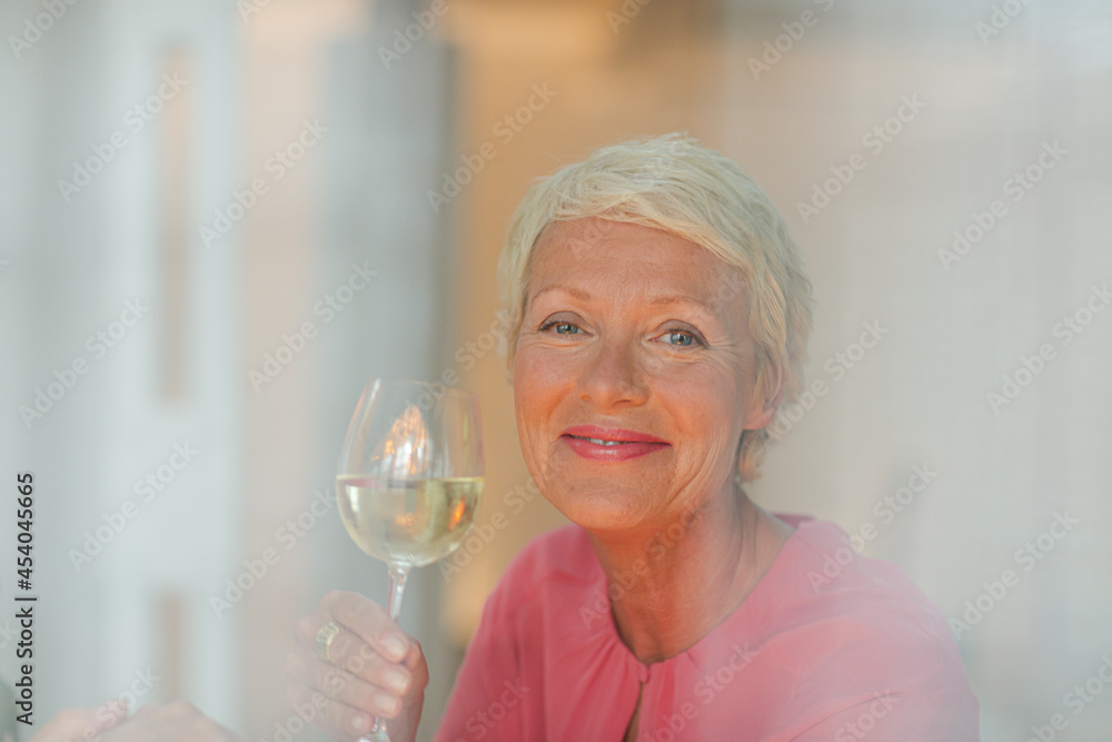 Older woman drinking glass of white wine Older woman drinking glass of white wine