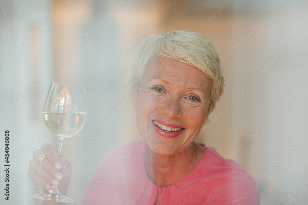 Older woman drinking glass of white wine Older woman drinking glass of white wine