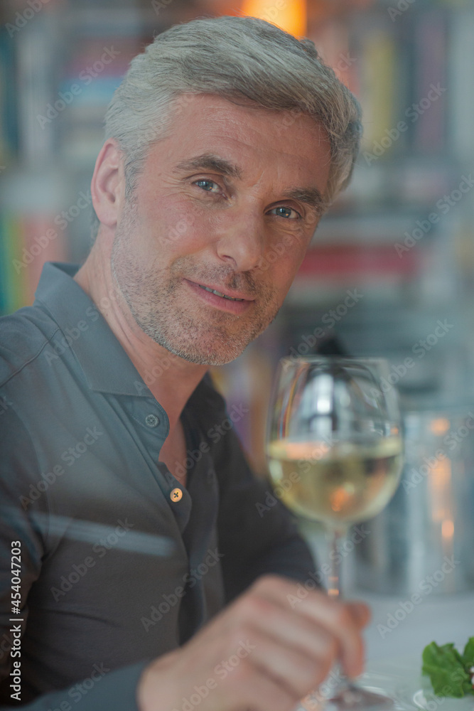 Smiling older man toasting with white wine Smiling older man toasting with white wine