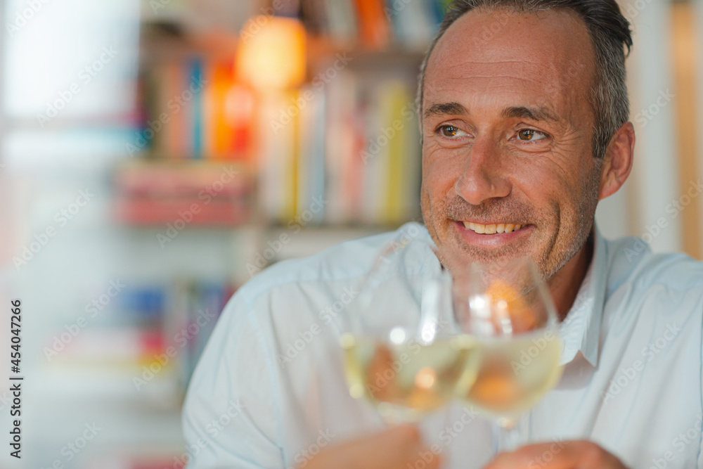 Older man drinking white wine at dinner Older man drinking white wine at dinner