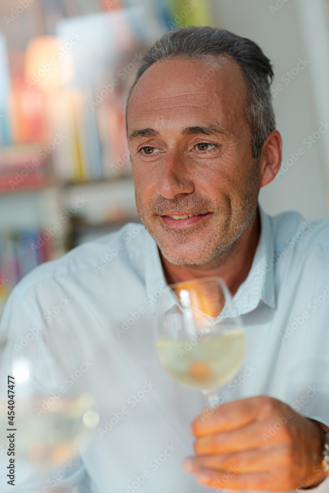 Older man drinking white wine at dinner Older man drinking white wine at dinner