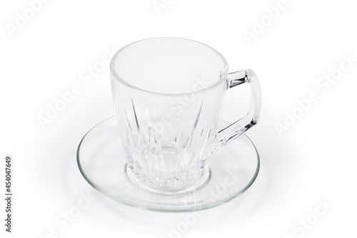 Empty glass cup on glass saucer on a white background