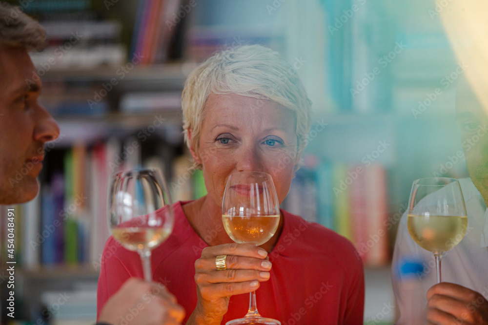Older friends toasting each other with white wine Older friends toasting each other with white wine