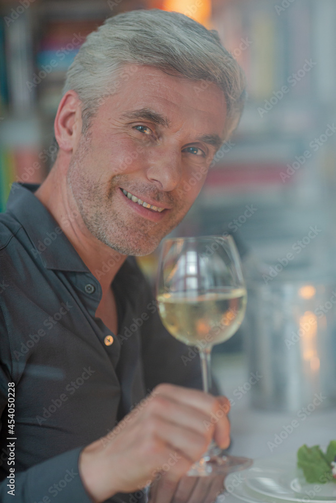 Smiling older man toasting with white wine Smiling older man toasting with white wine