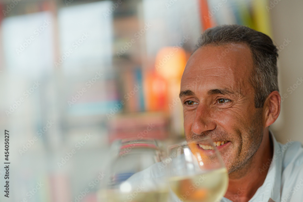 Older man drinking white wine at dinner