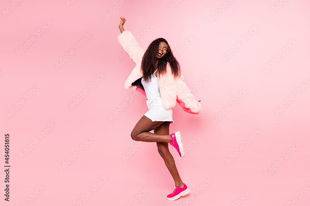 Full body portrait of excited positive dark skin girl closed eyes toothy smile partying isolated on pink color background