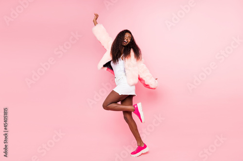 Full body portrait of excited positive dark skin girl closed eyes toothy smile partying isolated on pink color background