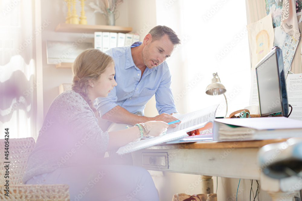 Fototapeta premium Father helping teenage daughter with her homework