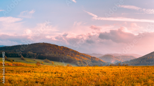 Fototapeta Naklejka Na Ścianę i Meble -  Bystrzyca Klodzka, mountain landscape, a view of the Bystrzyckie Mountains and farmland before sunset.