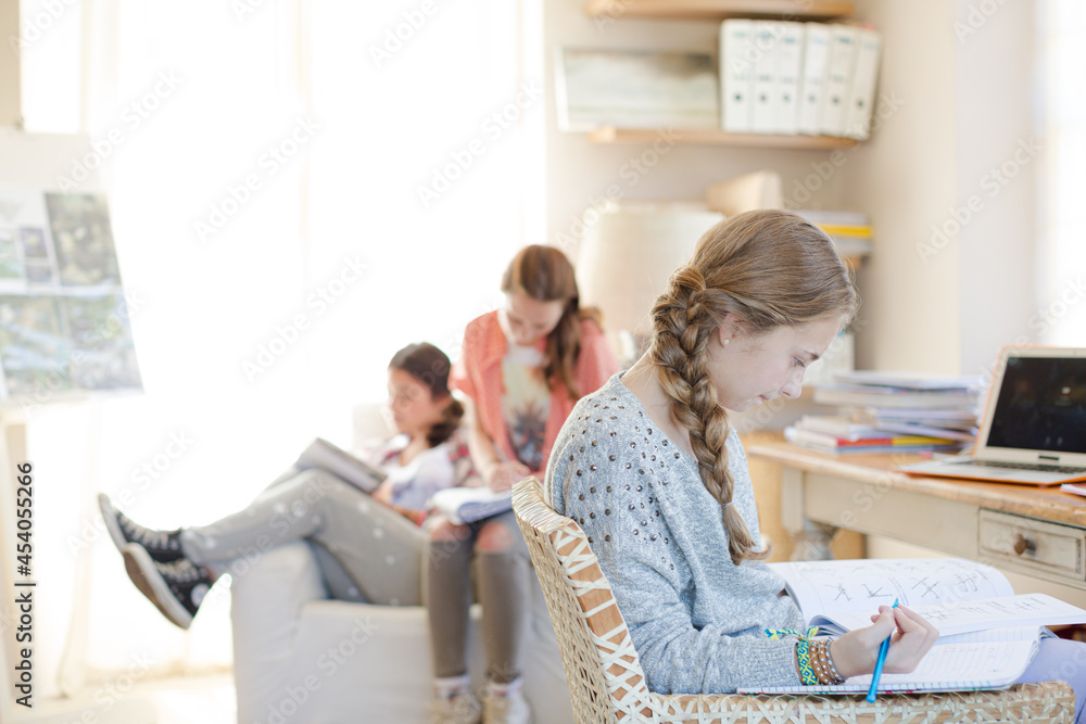 Obraz premium Three teenage girls doing homework in room