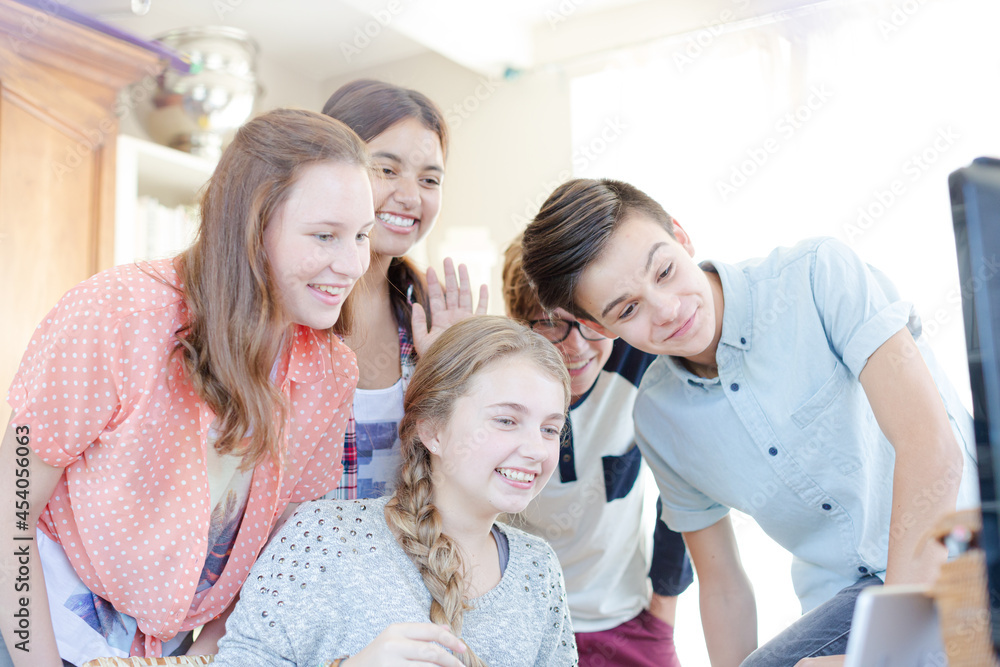 Fototapeta premium Group of teenagers waving while communicating via internet