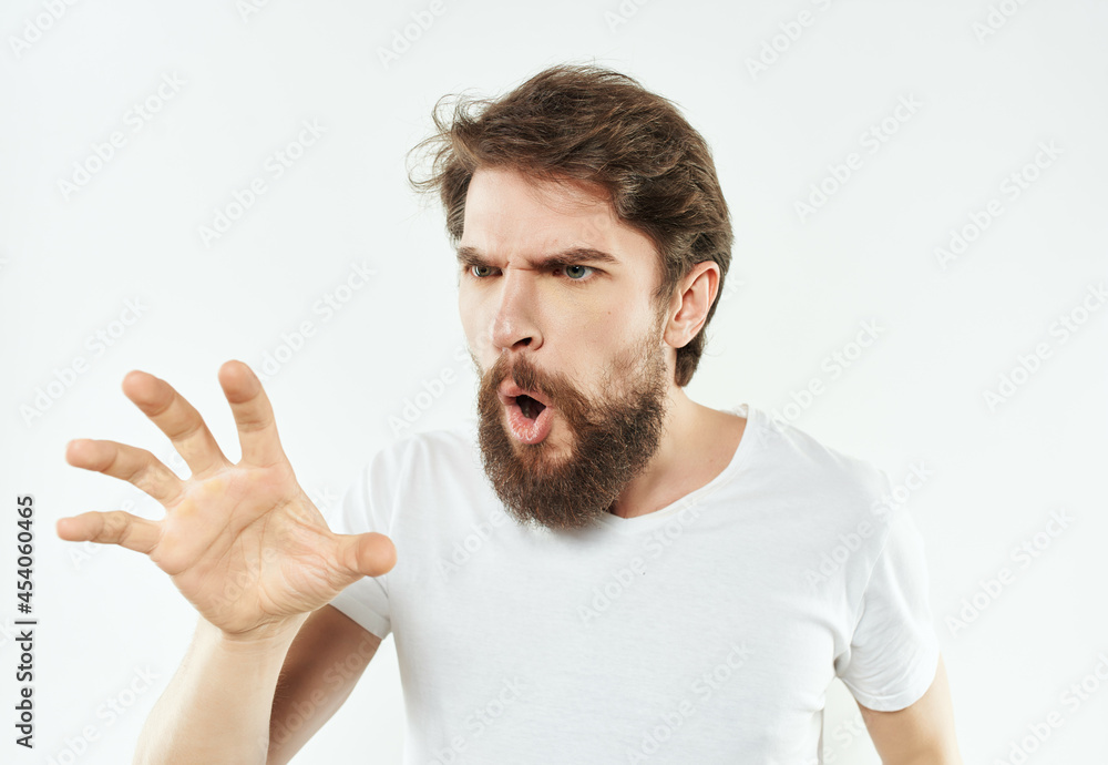emotional man in a white t-shirt irritated facial expression light background emotional man in a white t-shirt irritated facial expression light background
