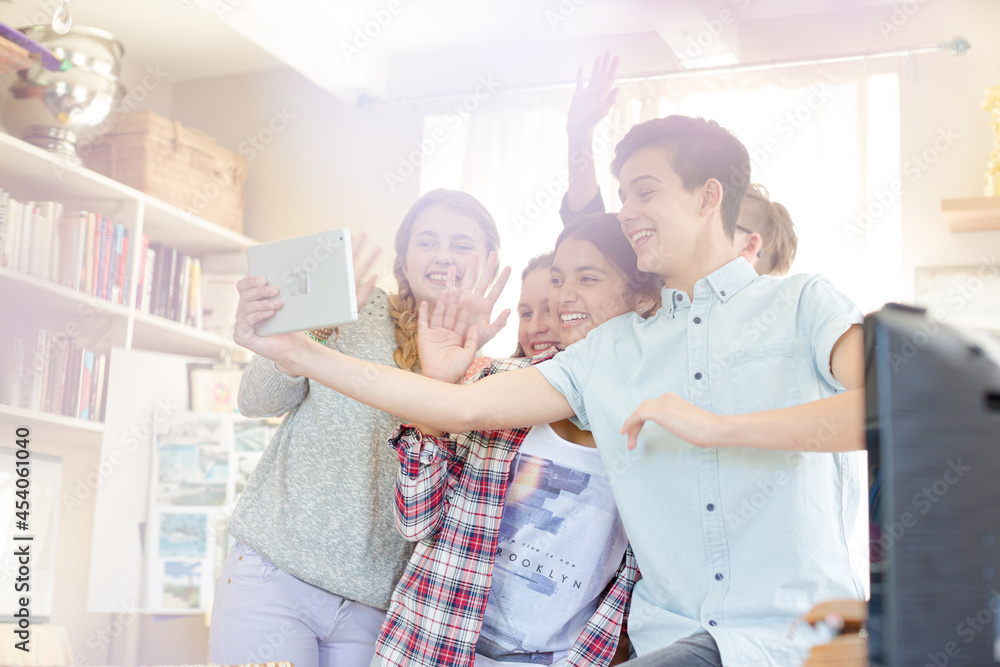 Group of teenagers waving while communicating via internet Group of teenagers waving while communicating via internet