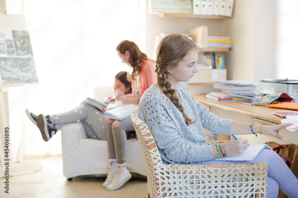 Obraz premium Three teenage girls doing homework in room