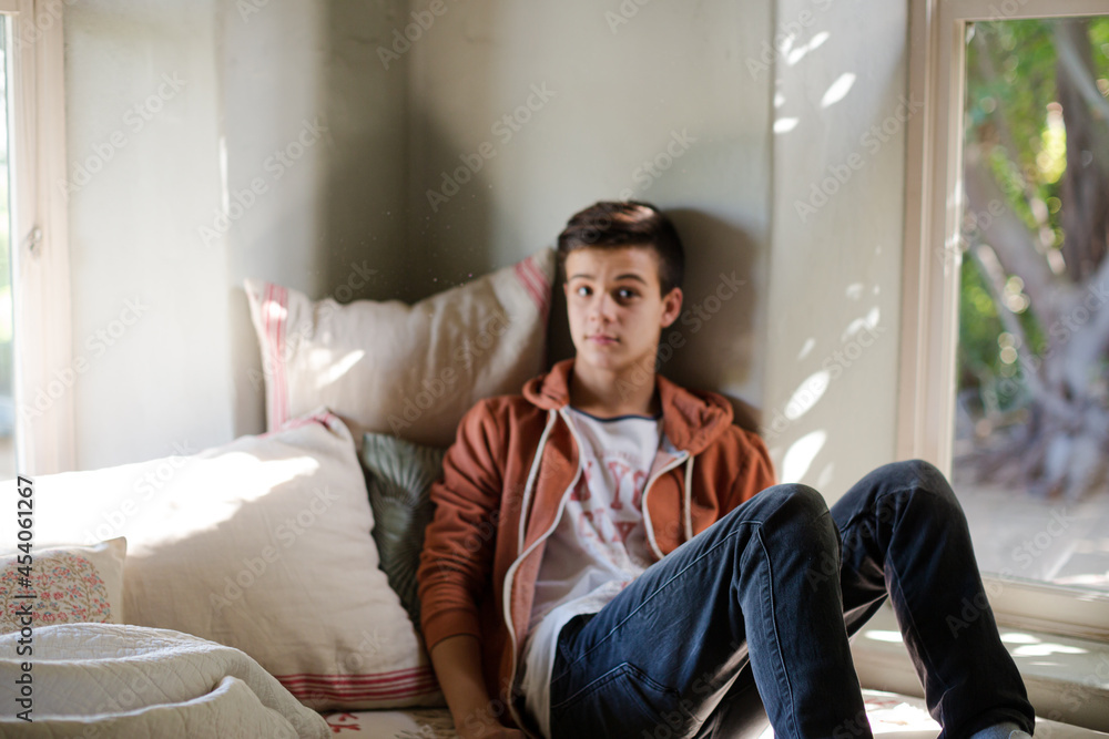 Teenage boy lying on sofa and thinking Teenage boy lying on sofa and thinking