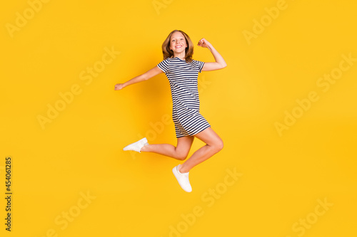 Full length profile portrait of cheerful pupil hurry fast have good mood look camera isolated on yellow color background