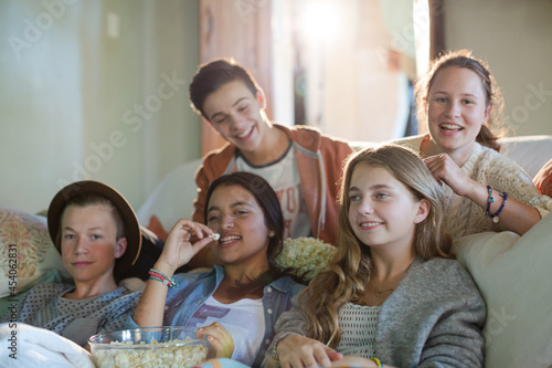 Group of teenagers having fun while watching tv on sofa © KOTO
