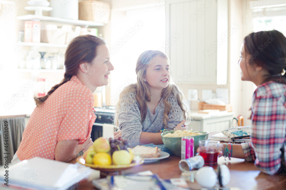 Teenage girls learning at table in kitchen Teenage girls learning at table in kitchen