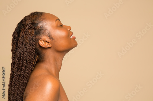 Profile of smiling shirtless woman with braided hair