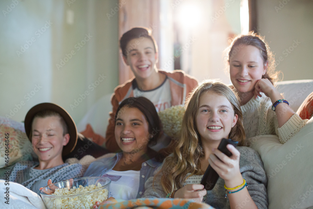 Group of teenagers having fun while watching tv on sofa Group of teenagers having fun while watching tv on sofa